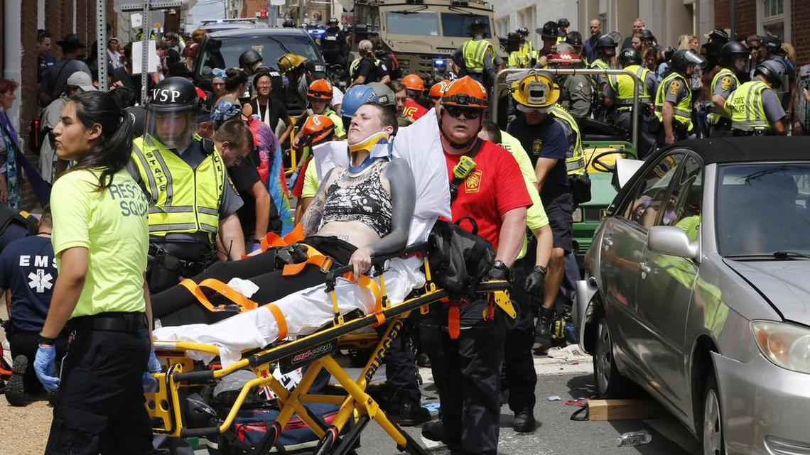 Rescue personnel help injured people who were hit when a car ran into a large group of protesters after a white nationalist rally in Charlottesville, Va. James Alex Fields Jr. was accused of using his car to kill 32-year-old Heather Heyer and injure 19 others who were staging a counter-demonstration.