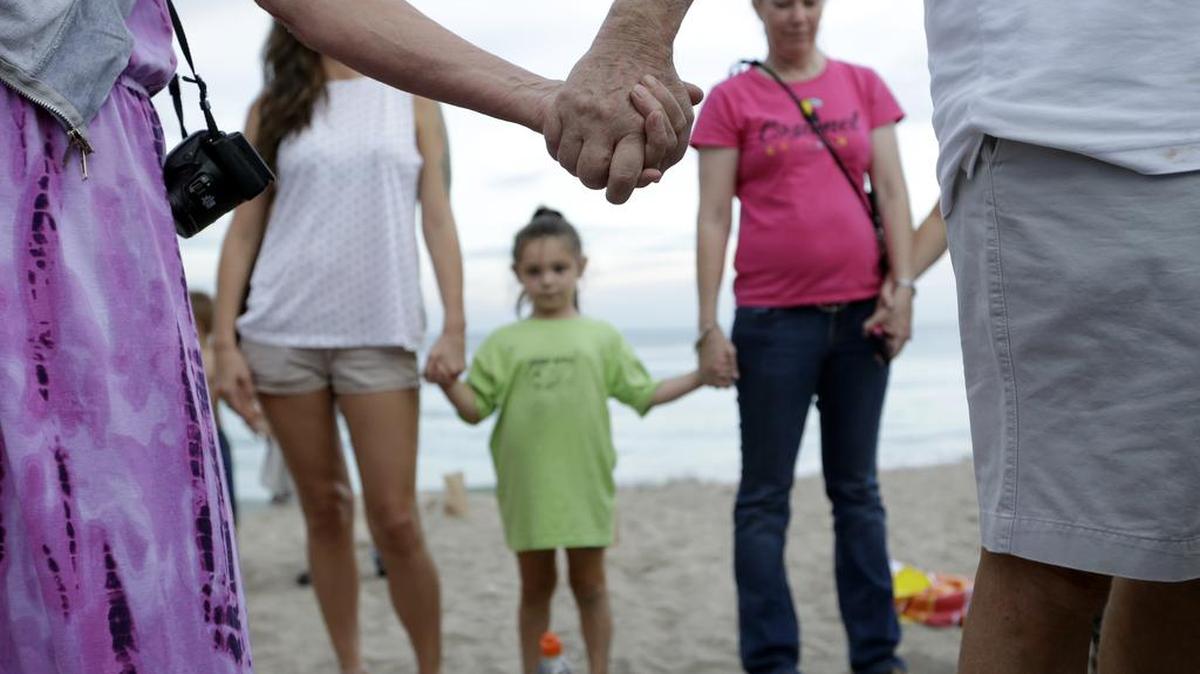 
People join hands during a vigil for Austin Stephanos and Perry Cohen, Tuesday, July 28, 2015, in Stuart, Fla. 
