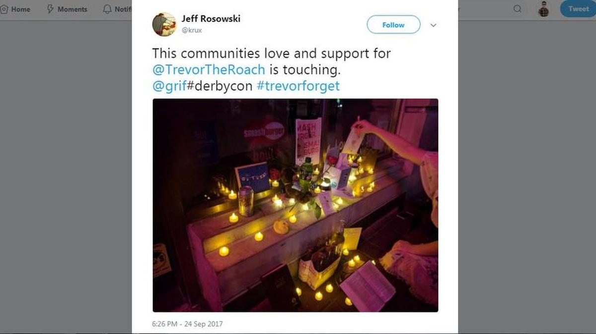 This Tweet shows a scene from a memorial for Trevor the cockroach, outside a Smash Burger in Lousiville, KY.