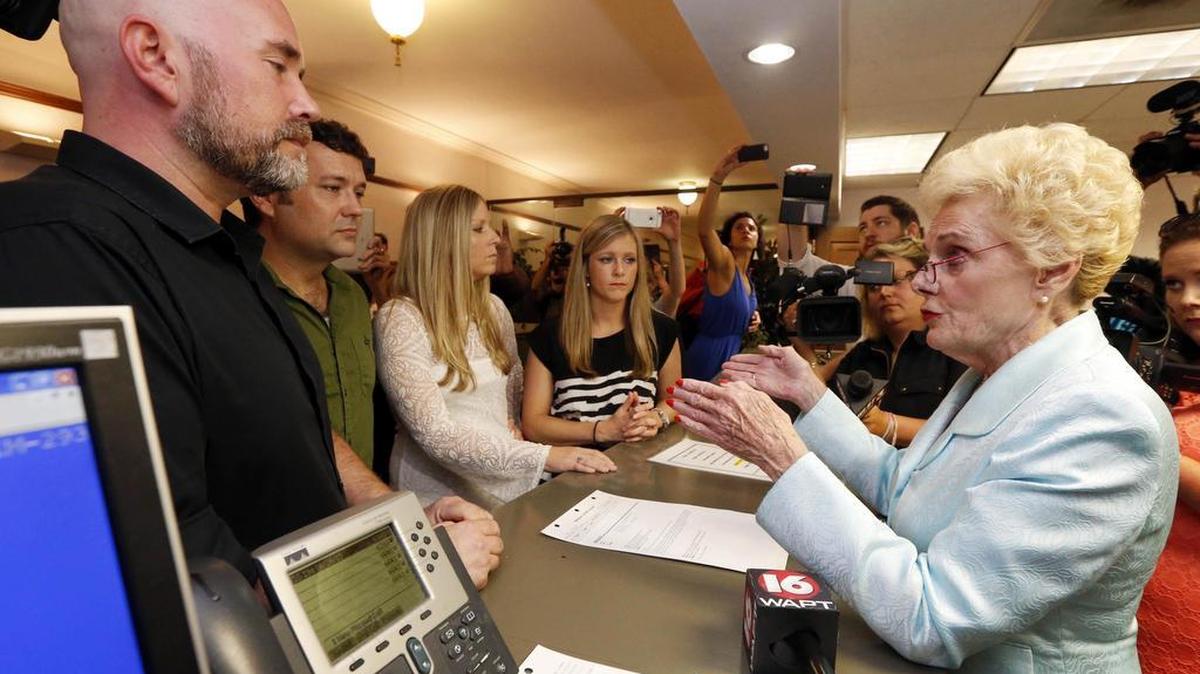 In this Friday, June 26, 2015 photo, Hinds County Circuit Clerk Barbara Dunn, right, reads an order by Mississippi Attorney General Jim Hood that puts a hold on circuit clerks from issuing marriage licenses to same sex couples, including, from left, Duane Smith and Knol Aust, both of Jackson, Miss., and Laurin Locke and Tiffany Brosh, at the Hinds County Court House in Jackson, Miss. They were able to get married three days later.