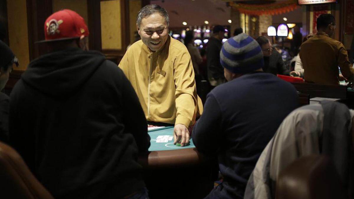 Wei Li, center left, deals a game of blackjack Wednesday to patrons at Twin River Casino in Lincoln, R.I. Casinos far from Las Vegas are experimenting with different ways to draw millennials. Twin River Casino removed 274 slot machines to make way in December for more poker and other table games favored by younger gamblers.
