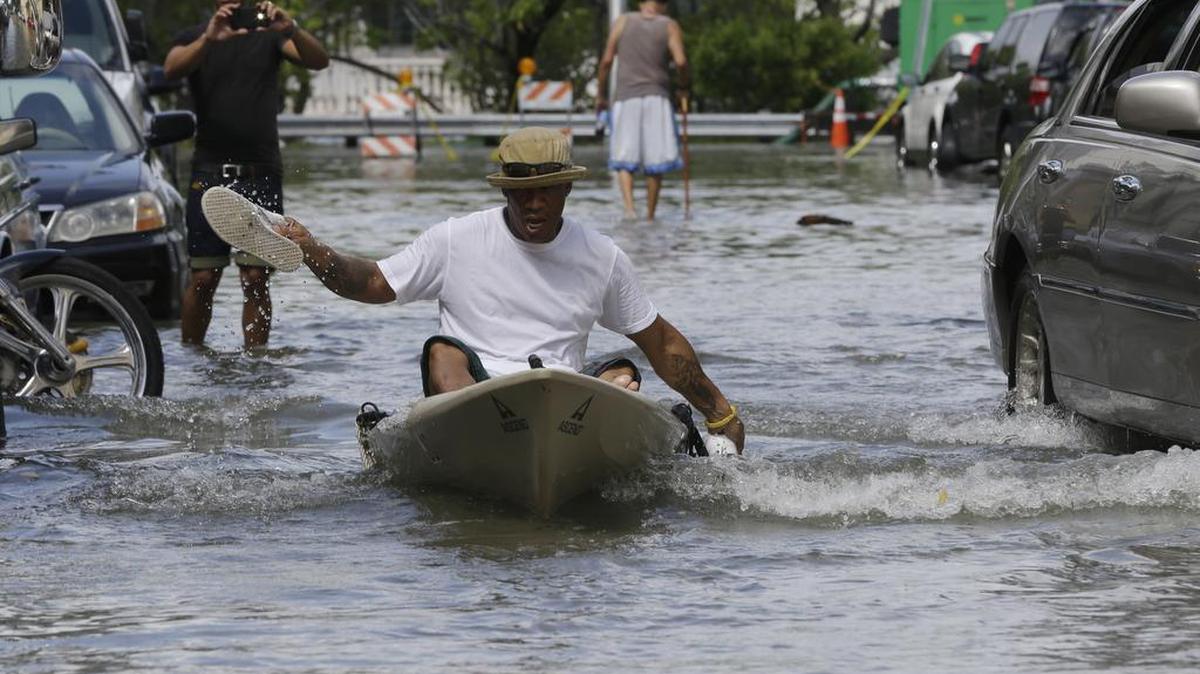 
Juan Carlos Sanchez uses his shoes to paddle a kayak on a flooded street near Collins Ave., Wednesday, Sept. 30, 2015, in Miami Beach, Fla. The street flooding was in part caused by high tides due to the lunar cycle, according to the National Weather Service.
