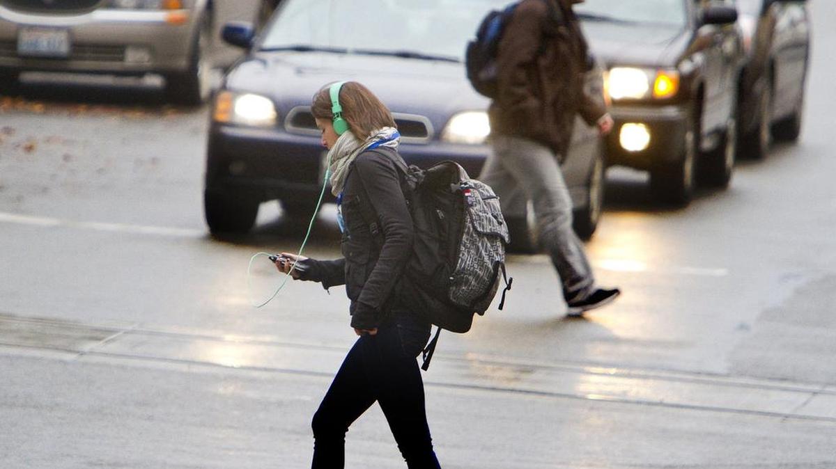 Pedestrians cross a Seattle intersection. A ban on crossing the street while staring at your smartphone or other electronic device goes into effect in Honolulu in October.