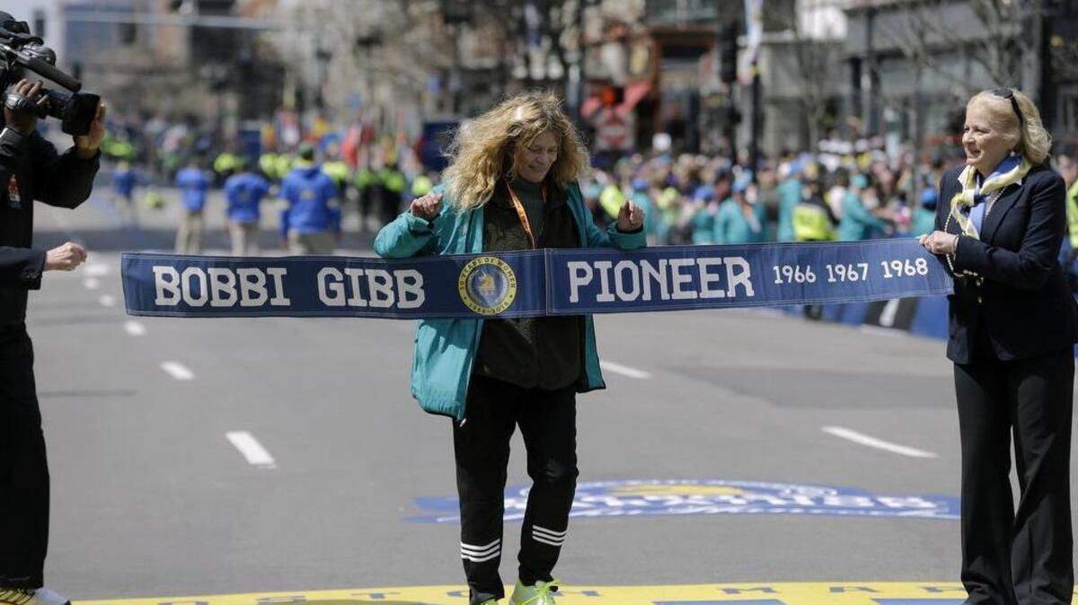 Bobbi Gibb, the first woman to run the Boston Marathon in 1966, crosses the finish line of the 120th Boston Marathon on Monday, April 18, 2016.