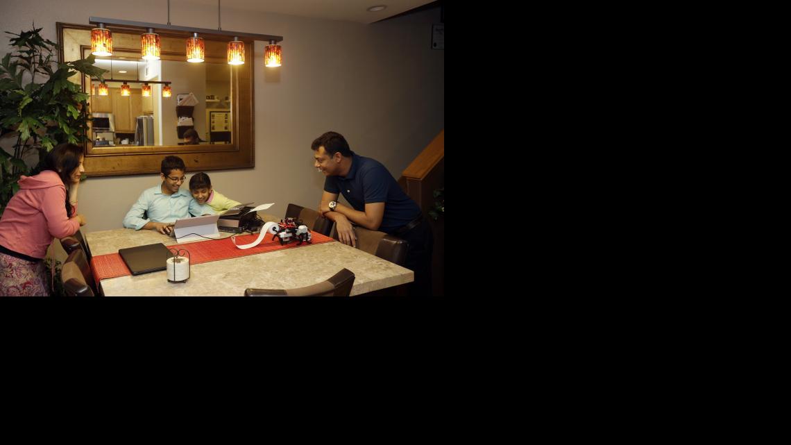 
Shubham Banerjee, center left, works on a prototype for his braille printer joined by his family including mom Malini, left, sister Anoushka, 8, center right, and dad Neil, right, at home Tuesday, Jan. 6, 2015, in Santa Clara, Calif. 
