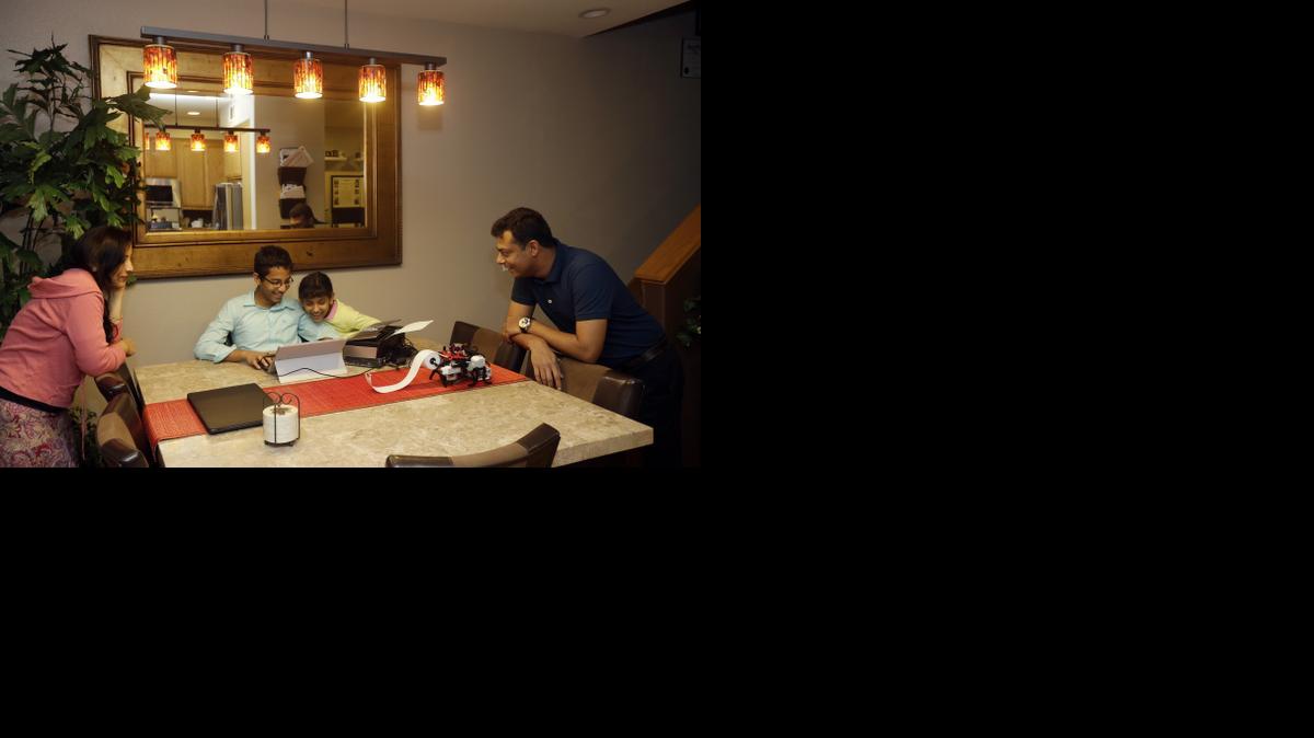 
Shubham Banerjee, center left, works on a prototype for his braille printer joined by his family including mom Malini, left, sister Anoushka, 8, center right, and dad Neil, right, at home Tuesday, Jan. 6, 2015, in Santa Clara, Calif. 
