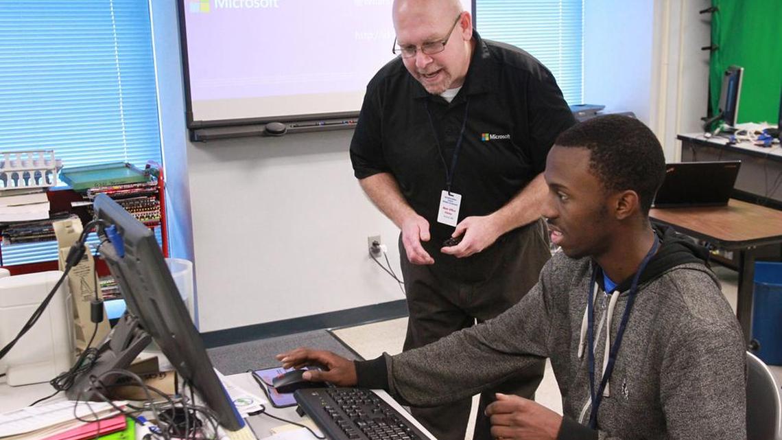 In a 2014 visit to Belleville East High School in Illinois, Bill Fink talks with senior Don Proctor about a website that Proctor helped design. Fink spoke to the students about careers in technology.