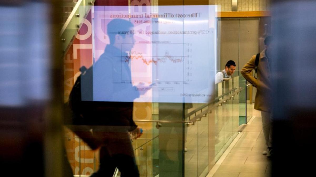The slide of a chart being used in the course "Digital Currenty, Blockchains, and the Future of the Financial Services Industry” is reflected in an auditorium window leading to a hallway, at New York University in New York, Jan. 29, 2018.