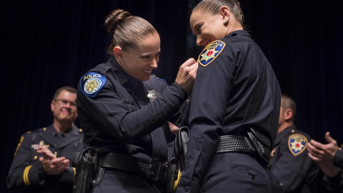 Sacramento Police Department officer Alexis Grove pins her twin sister Alana Grove during a swearing-in ceremony for Roseville police officers at Roseville High School on Friday, Aug. 5, 2016, in Roseville, Calif.