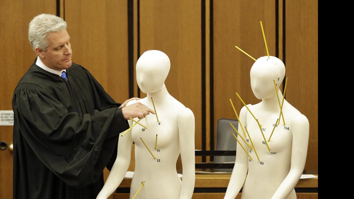 
County Common Pleas Court Judge John O'Donnell points to mannequins marked with the gunshot wounds that the two motorists suffered during the trial May 23, 2015, in Cleveland of Michael Brelo, a patrolman charged in the shooting deaths of two unarmed suspects. 
