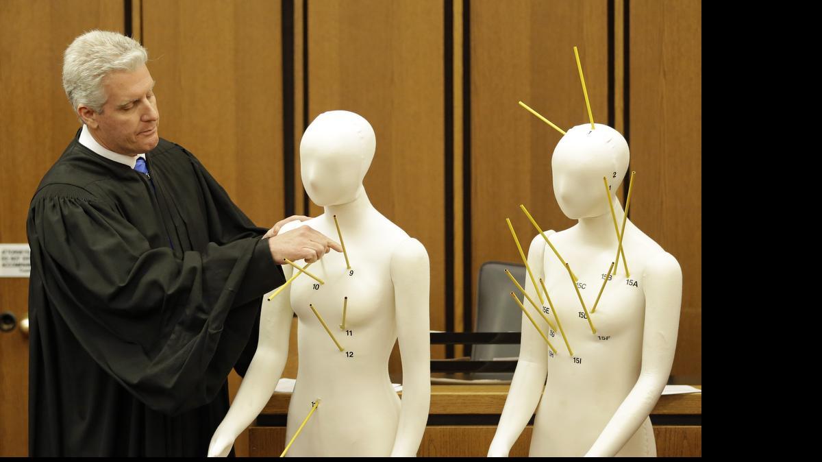 
County Common Pleas Court Judge John O'Donnell points to mannequins marked with the gunshot wounds that the two motorists suffered during the trial May 23, 2015, in Cleveland of Michael Brelo, a patrolman charged in the shooting deaths of two unarmed suspects. 
