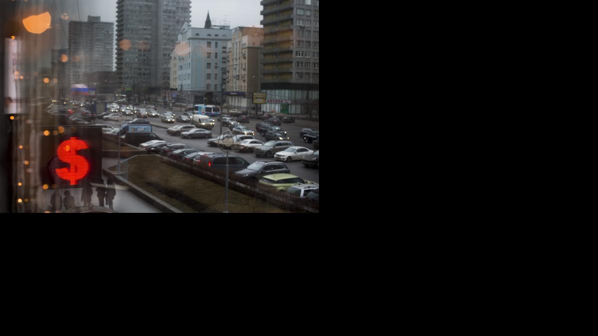 In this Wednesday, Dec. 17, 2014 file photo, a sign in Moscow, Russia indicates the spread on the dollar-ruble rate.