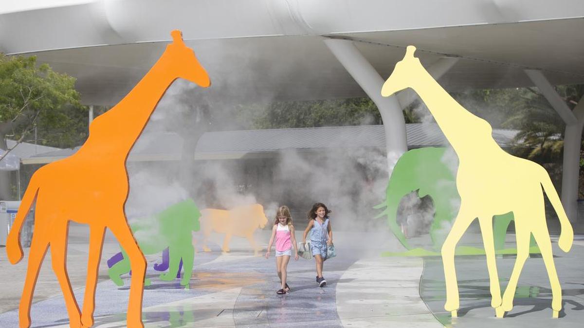 Visitors walk through misters shaped as animals at Zoo Miami, Friday, July 15, 2016, in Miami. Zoo Miami is one of several zoos and wildlife shelters in the path of Hurricane Irma preparing for the storm by staying put.