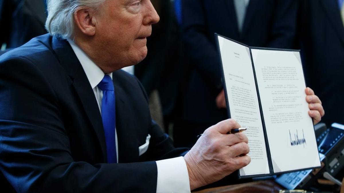 President Donald Trump shows off his executive order calling for reviving the Dakota Access pipeline on Tuesday, Jan. 24, 2017, in the Oval Office of the White House.