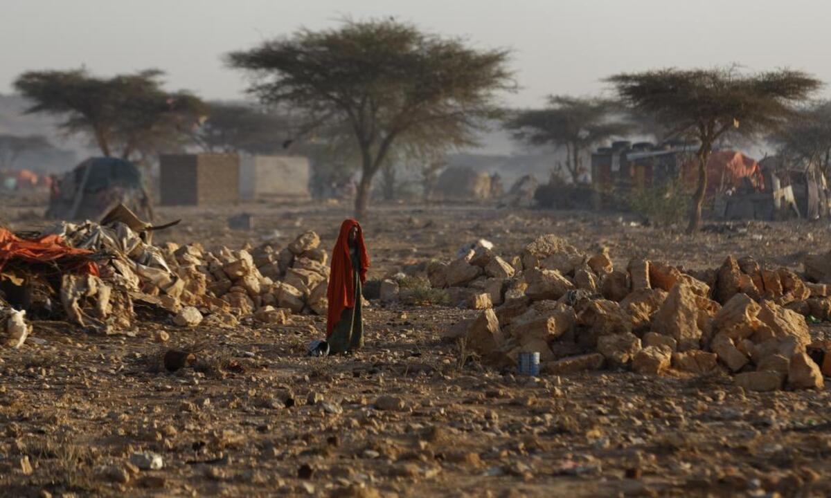 A Somali woman walks through a camp of people displaced from their homes elsewhere in the country by the drought, shortly after dawn in Qardho, Somalia Thursday, March 9, 2017. Somalia's government has declared the drought a national disaster, and the United Nations estimates that 5 million people in this Horn of Africa nation need aid, amid warnings of a full-blown famine.