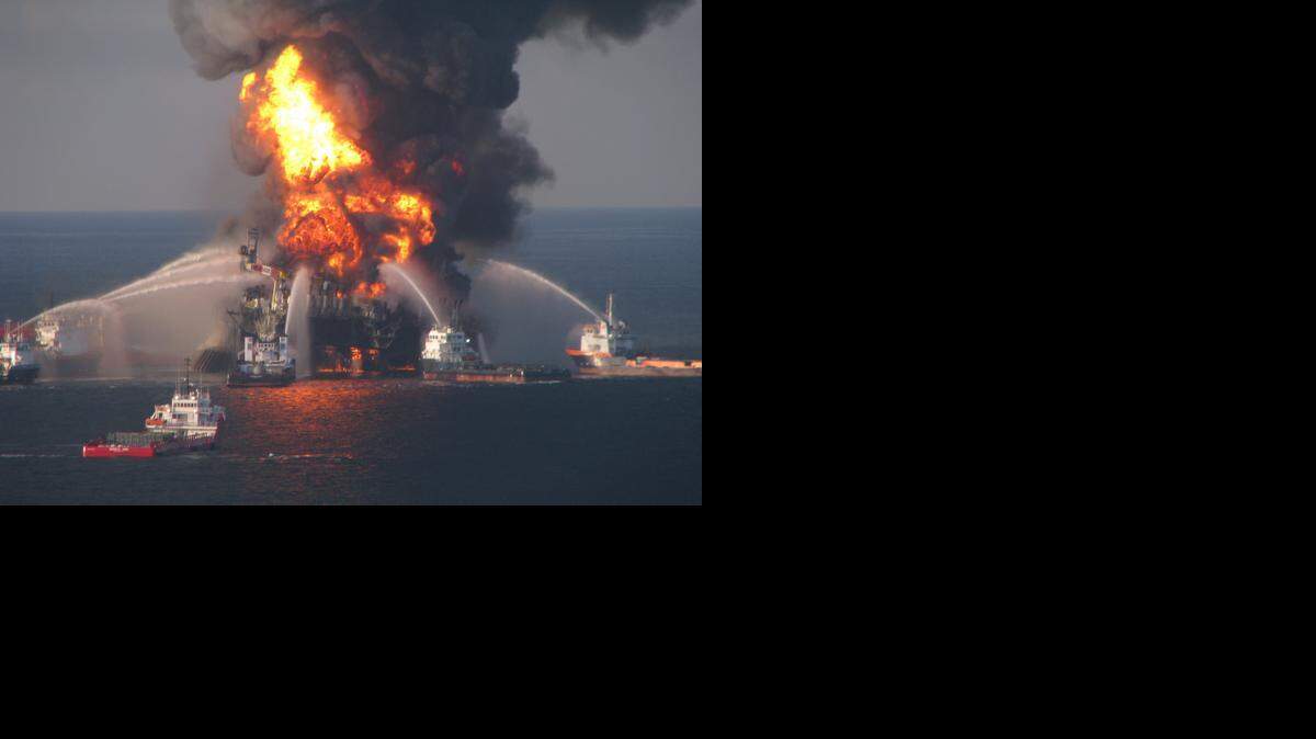 
Fire boat response crews battle the blazing remnants of the off shore oil rig Deepwater Horizon April 21, 2010. A Coast Guard MH-65C dolphin rescue helicopter and crew document the fire aboard the mobile offshore drilling unit Deepwater Horizon, while searching for survivors April 21, 2010. Multiple Coast Guard helicopters, planes and cutters responded to rescue the Deepwater Horizon's 126 person crew. 
