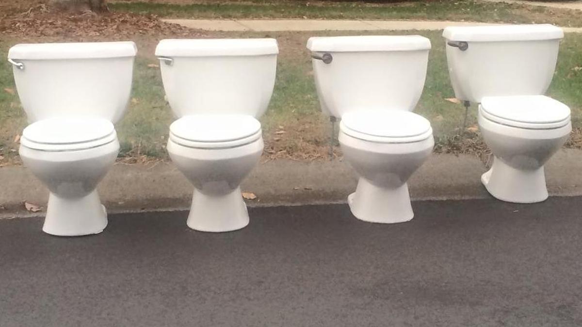 Four toilets lined up on a curb in southeast Charlotte, N.C.