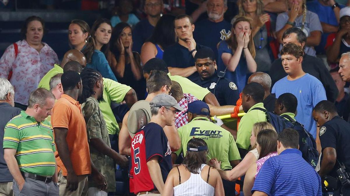 
Rescue workers carry an injured fan from the stands at Turner Field during a baseball game between Atlanta Braves and New York Yankees, Aug. 29, 2015, in Atlanta. The fan fell from the upper deck into the lower-level stands and was given emergency medical treatment before being taken to a hospital.
