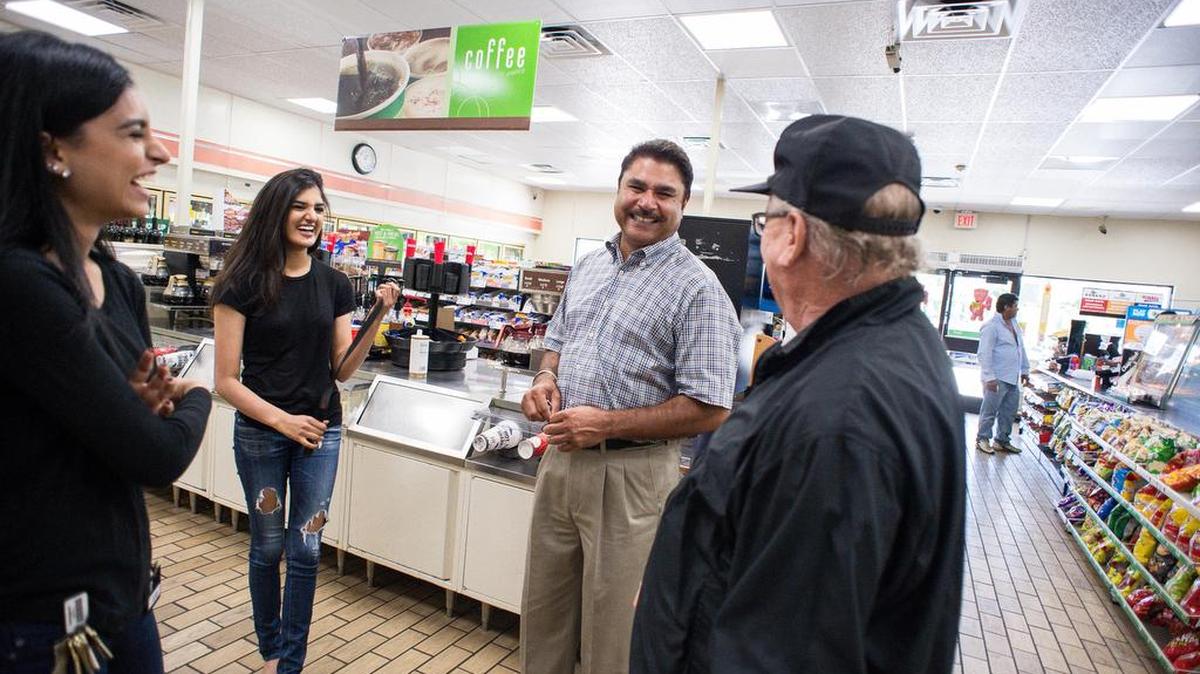 Ronnie Guyer, right, talks Tuesday with Balbir Atwal, owner the 7-Eleven franchise in Chino Hills, Calif., where a winning Powerball ticket worth $528.8 million purchased in January was claimed Tuesday. “Everybody is like, this is a lucky place so everybody comes here to play,” said Atwal, whose daughters Sonia, left, and Sharan, are also pictured.