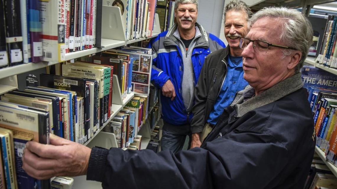 Jon Kramer, center, and his brothers Bill, left, and Michael, visit the Twinbrook library, in Rockville, Md., to which they have made a donation after discovering long overdue books in their late father's possesions.
