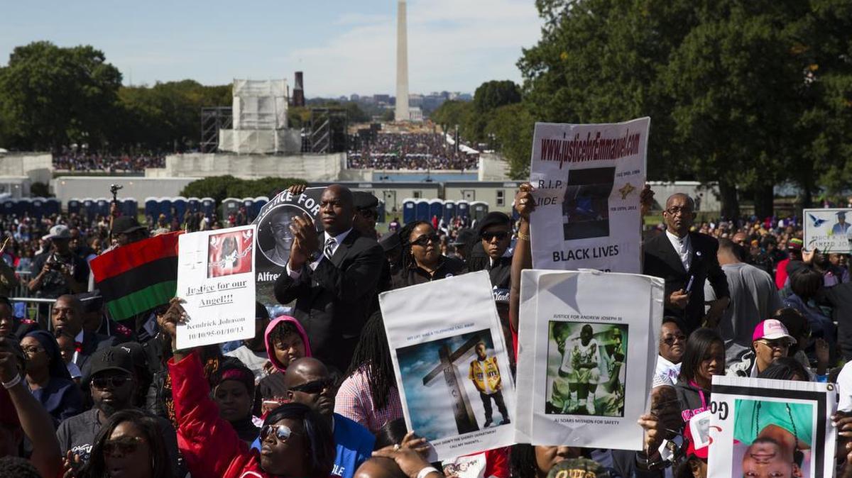 
People cheer during a rally to mark the 20th anniversary of the Million Man March on Saturday, Oct. 10, 2015, in Washington. Waving flags, carrying signs and listening to speeches and songs, the crowd gathered at the U.S. Capitol and spread down the Mall under on a sunny and breezy fall day.
