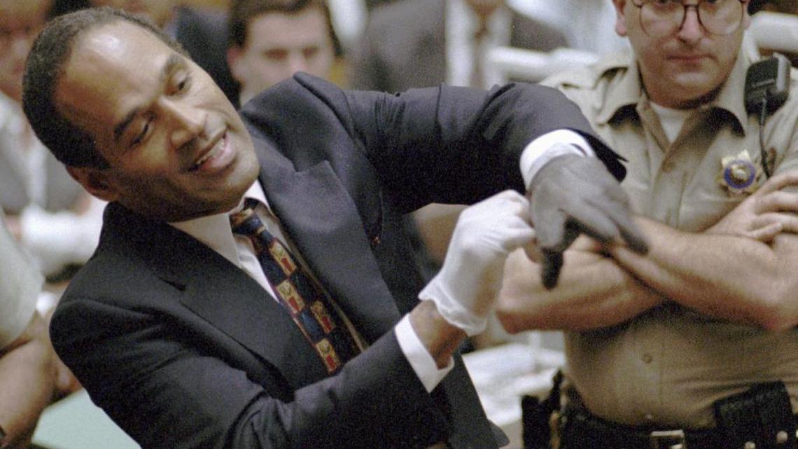 O.J. Simpson tries on one of the leather gloves during his trial in Los Angeles in1995 that prosecutors say he wore the night his ex-wife, Nicole Brown Simpson, and Ron Goldman were murdered.