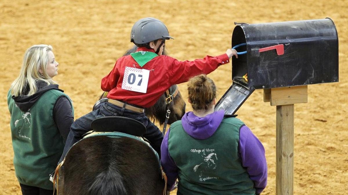 Colby Tutt retrieves a ring from a mailbox as one of the tasks he and his horse perform at the Chisholm Challenge riding event for special needs riders at Will Rogers Memorial Center in January 2013.