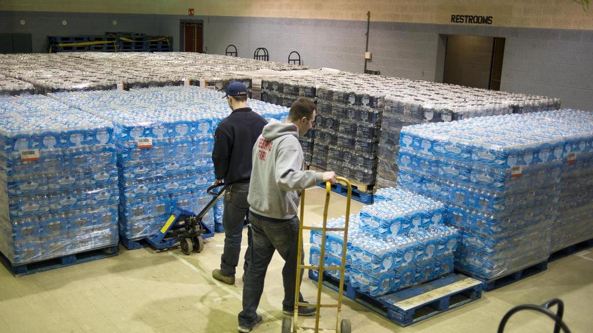 Workers move pallets holding bottled water at a distribution site in Sebring, Ohio, Feb. 2, 2016. Water contamination has turned up in scores of communities in recent years, and experts cite holes in the safety net of rules and procedures.