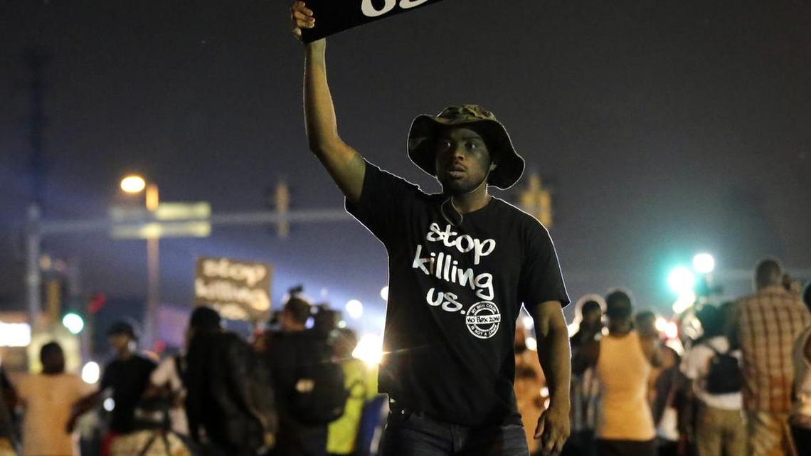 
 Protesters walk through the streets after a standoff with police in Ferguson, Mo., on Aug. 18, 2014, a little over a week after white police office Darren Wilson fatally shot Michae; Brown Jr., a black unarmed 18-year-old in the street in Ferguson, a middle-class St. Louis suburb that quickly became known around the world. 

