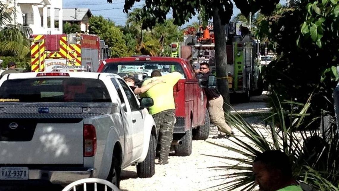 A woman comforts a man at the site of Monday’s tragedy in Key Largo during which three utility workers died in a wastewater trench.