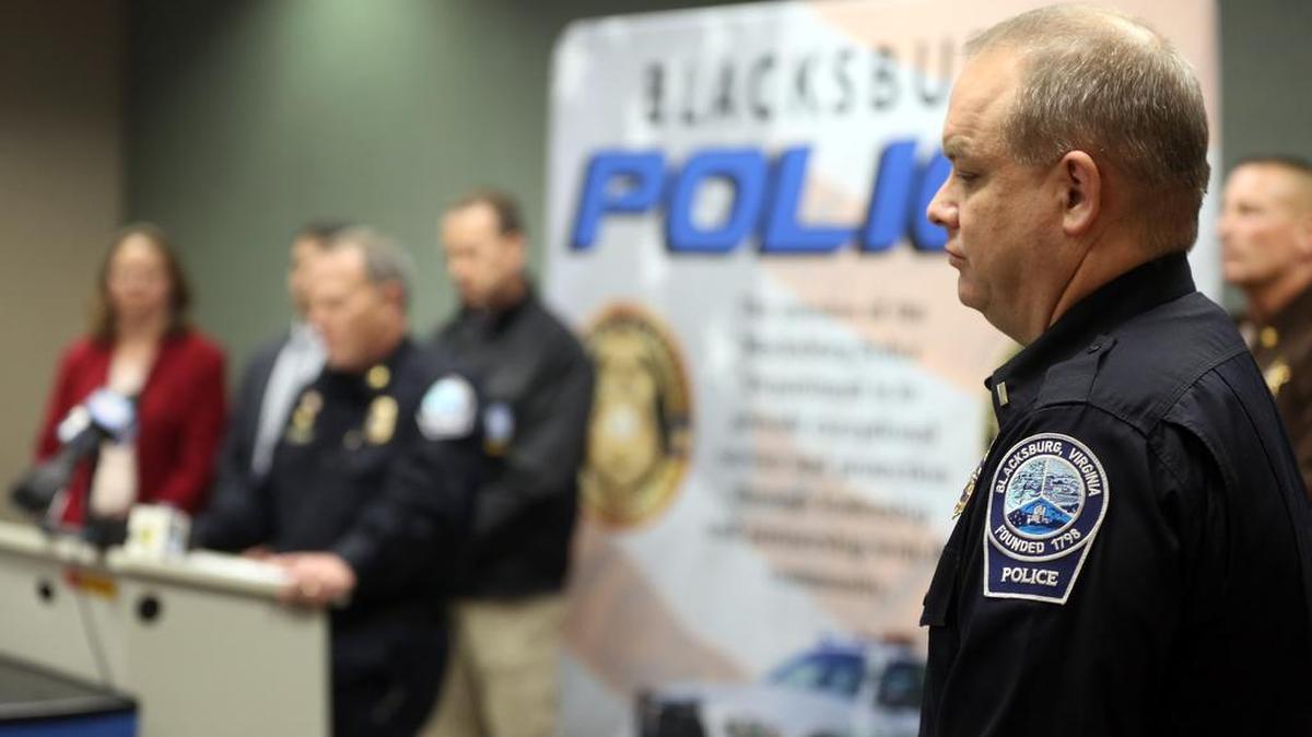 Blacksburg police Lt. Mike Albert, right, listens as Blacksburg Police Chief Anthony Wilson speaks during a news conference Saturday, Jan. 30, 2016, in Blacksburg Va.