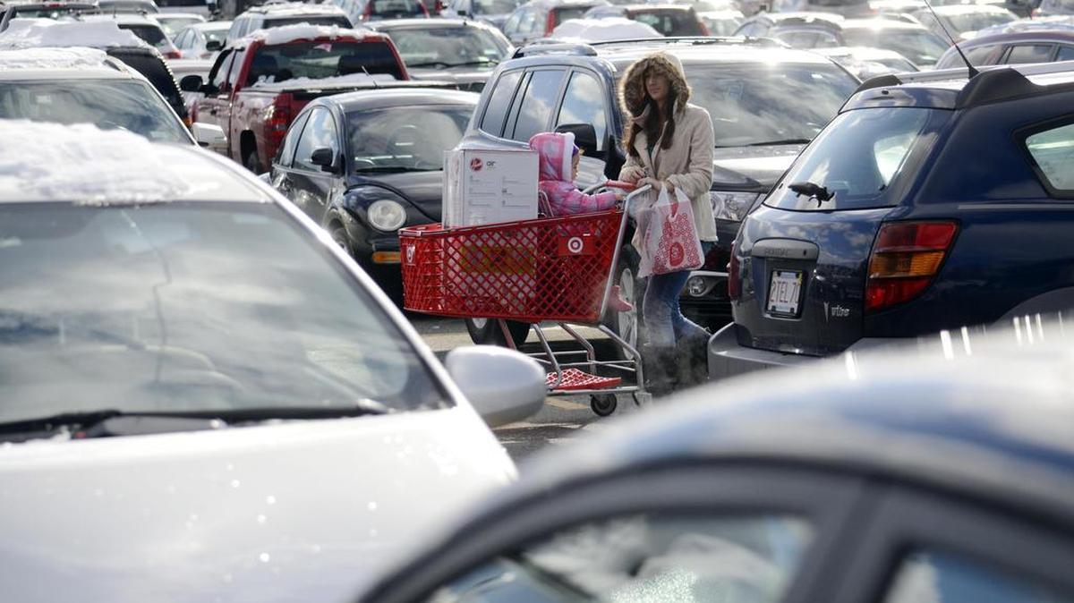 A woman walks through a packed parking lot at the Berkshire Mall on Black Friday 2014 in Lanesborough, Mass.