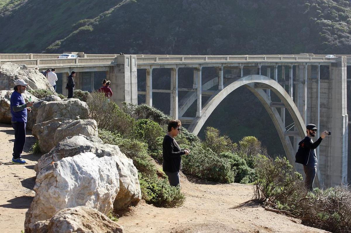Travelers stop to take photos along the Big Sur coast near the Bixby Bridge on Highway 1.