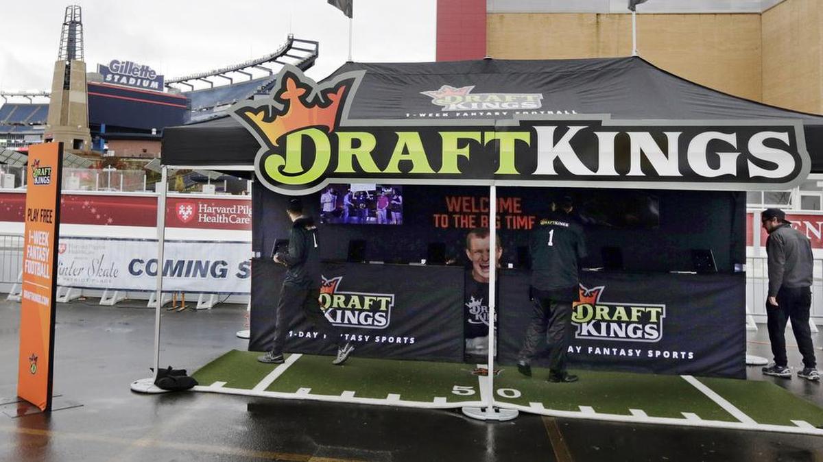 In this Oct. 25, 2015, photo, workers set up a DraftKings promotions tent in the parking lot of Gillette Stadium, in Foxborough, Mass., before an NFL football game between the New England Patriots and New York Jets. New York's attorney general on Tuesday, Nov. 10, 2015, ordered the daily fantasy sports companies DraftKings and FanDuel to stop accepting bets in the state, saying their operations amount to illegal gambling.