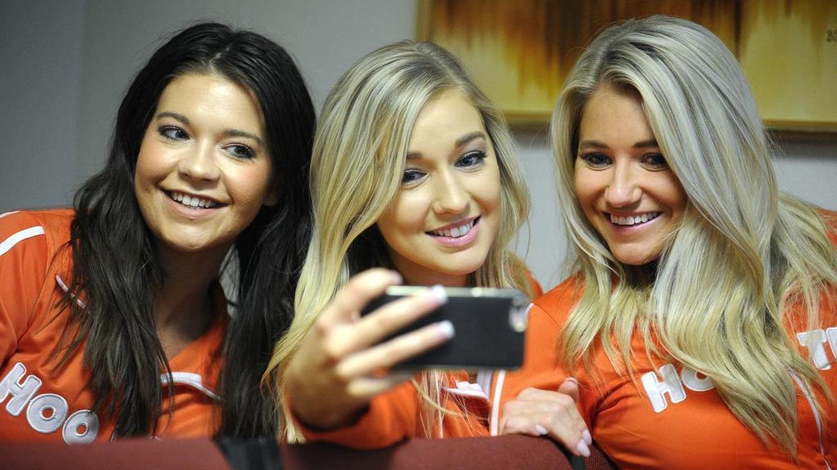 Three Hooters waitresses take a selfie during a break in theTexas Alcoholic Beverage Commission hearing about the restaurant’s application for a liquor license. The Downtown Fort Worth Neighborhood Committee is opposing the license.