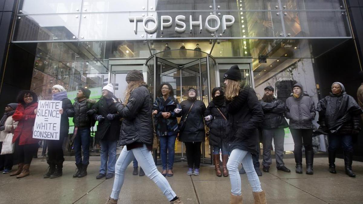 Protesters block an entrance to Top Shop store on Friday, Nov. 27, 2015, in Chicago as community activists and labor leaders hold a demonstration billed as a "march for justice" in the wake of the release of video showing an officer fatally shooting Laquan McDonald.