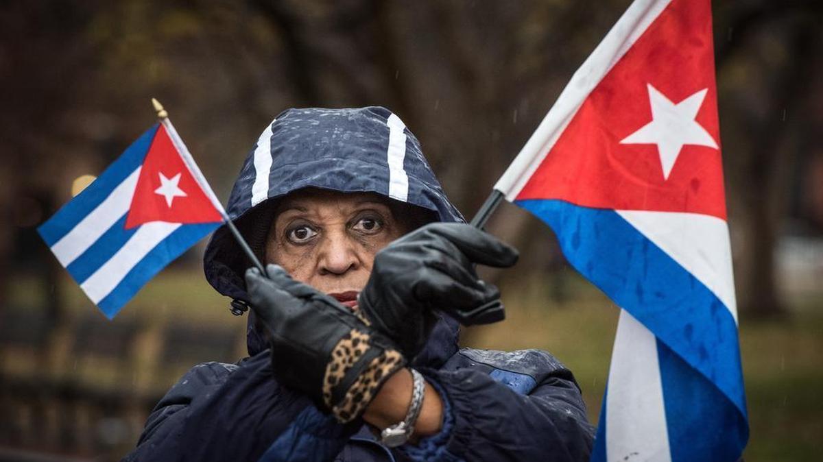 Violetta Pons of Miami, Fla., holds Cuban flags to raise awareness of continued oppression and human rights abuses by the Castro regime during a rally across the street from the White House in Washington, D.C., on Dec. 17, 2015.