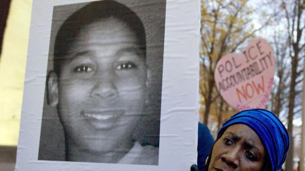 In this Dec. 1, 2014 photo, Tomiko Shine holds up a picture of Tamir Rice, the 12-year-old boy fatally shot by police in Cleveland.