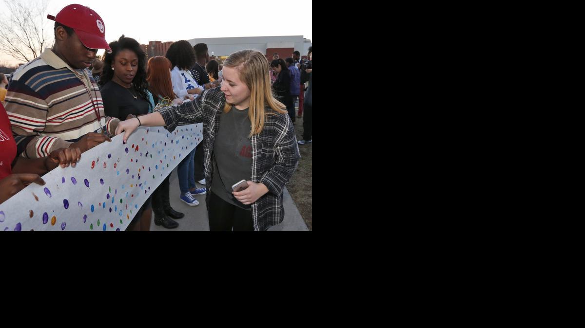 
University of Oklahoma junior Brooke Aston, right, of Rockwall, Texas, adds her fingerprint to a sign to be carried to the now closed University of Oklahoma's Sigma Alpha Epsilon fraternity house during a rally in Norman, Okla., Tuesday, March 10, 2015. The university's president expelled two students Tuesday after he said they were identified as leaders of a racist chant captured on video during a fraternity event. 
