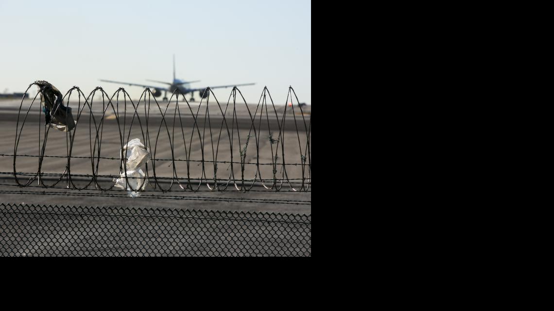 
In this Friday, Jan. 23, 2015 photo, a passenger jet touches down behind the razor wire of a perimeter fence at the Los Angeles International Airport. An Associated Press investigation found 268 perimeter breaches since 2004 at airports that together handle three-quarters of U.S. commercial passenger traffic. And that’s an undercount, because two airports among the 31 that AP surveyed didn’t have data for all years. 
