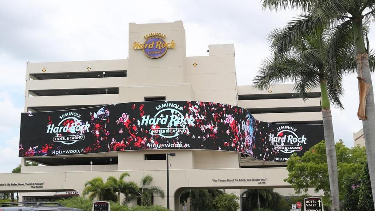 A large, digital screen welcomes guests to the Seminole Hard Rock Hotel & Casino near Hollywood. The hotel is one outpost of a global brand with 22 hotels and one racino, and entities in 68 countries between its hotels, cafes, casinos and concert venues.