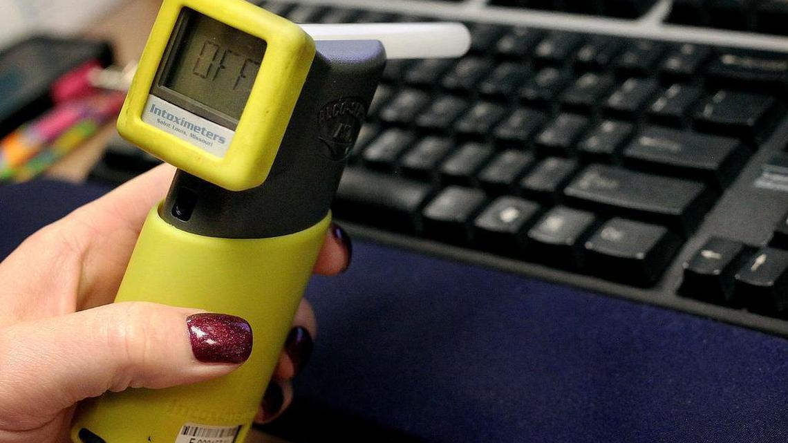 An officer holds a device people accused or convicted of an alcohol-related crimes blow into to test their sobriety in Sioux Falls, S.D.