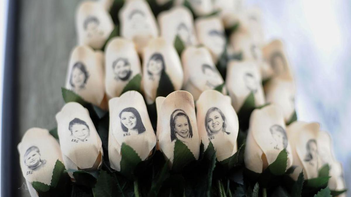 Rosas blancas con los rostros de las víctimas de los disparos en la escuela primaria Sandy Hook en un poste de teléfono cerca de la escuela en Newtown, Connecticut, en enero de 2013. En los tres años desde que un joven con problemas mentales mató a 26 niños y maestros allí, muchos estados han movido en la dirección opuesta, abrazando el axioma de la Asociación Nacional del Rifle que se necesitan más armas para disuadir a los fusilamientos masivos.