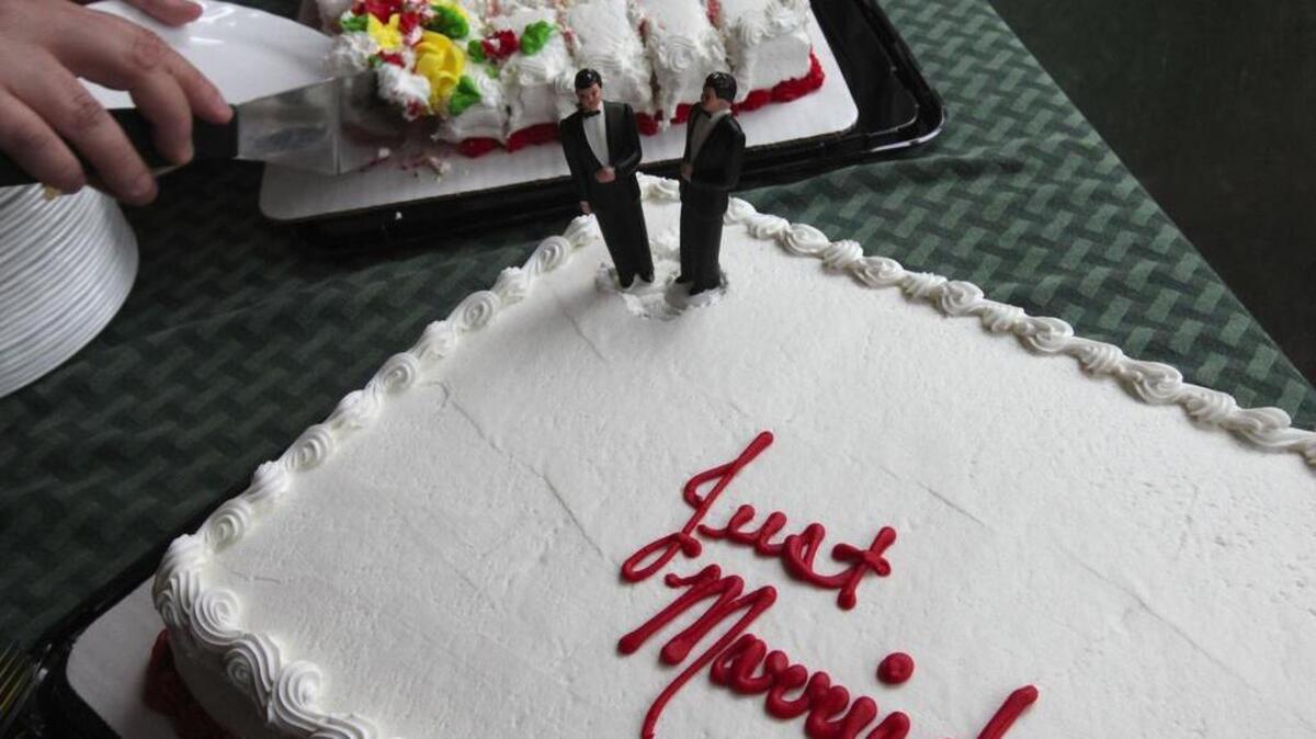 
Wedding figures adorn a cake for a same-sex couple. 
