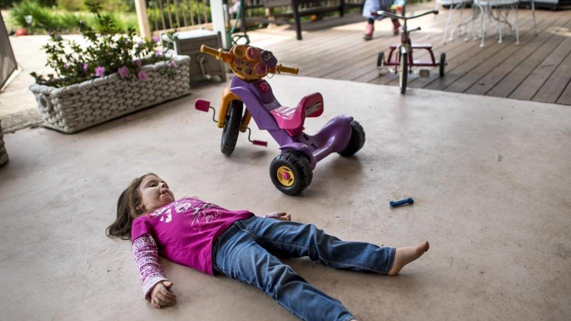 Brontë, 4, relaxes as sister Bridget, 3, runs around in the background Friday in Fair Oaks. Their mother says parents can fixate on super-cleanliness.