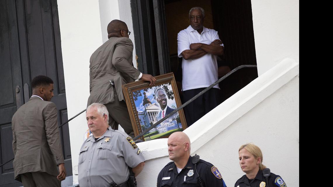 
A portrait of Sen. Clementa Pinckney, one of the nine killed in last week's shooting, is carried in for his wake at Emanuel AME Church, Thursday, June 25, 2015, in Charleston, S.C. The first funerals of some of those slain began Thursday at nearby churches with a viewing for Pinckney inside Emanuel on Thursday evening. President Barack Obama will deliver the eulogy at Pinckney's funeral Friday at a nearby college arena. 
