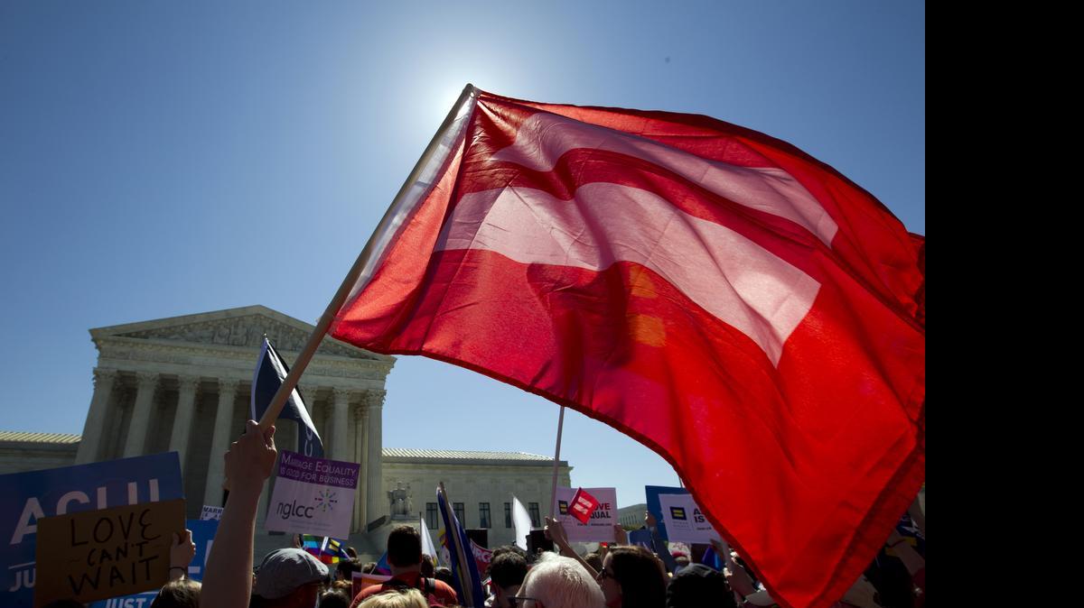 
An equality flag waves during a demonstrators in front of the Supreme Court in Washington, Tuesday, April 28, 2015. The Supreme Court is set to hear historic arguments in cases that could make same-sex marriage the law of the land. The justices are meeting Tuesday to offer the first public indication of where they stand in the dispute over whether states can continue defining marriage as the union of a man and a woman, or whether the Constitution gives gay and lesbian couples the right to marry. 
