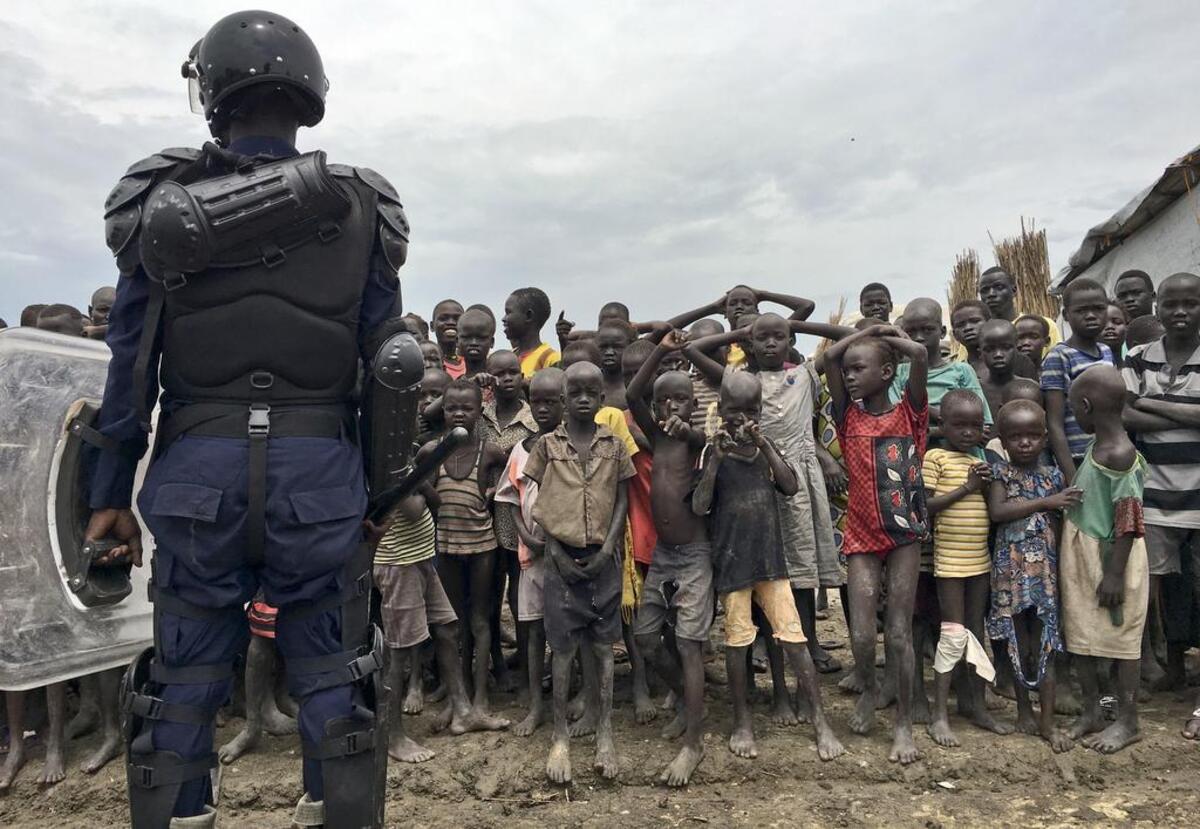 A crowd of displaced people look on as members of the U.N. multi-national police contingent provide security during a visit of UNCHR High Commissioner Filippo Grandi to South Sudan's largest camp for the internally-displaced, in Bentiu, South Sudan Sunday, June 18, 2017. Thousands of South Sudanese now live in U.N. protected camps, including eighty percent of Bentiu's population.