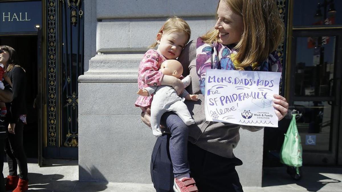Kim Turner holds her daughter Adelaide Turner Winn before a rally supporting paid family leave at City Hall in San Francisco, Tuesday, April 5, 2016.