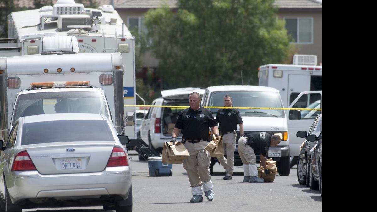 
Police officers carry evidence bags at a crime scene Sunday on Nob Hill Court where five bodies were found in a Modesto home Saturday.


